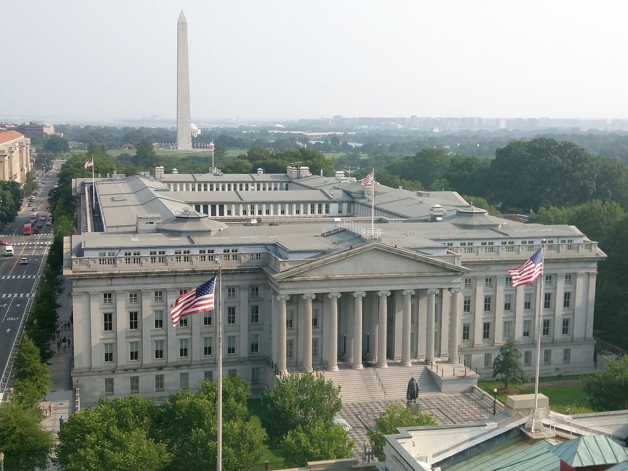 The U.S. Treasury Building in Washington seen from above, with the Washington Monument behind it