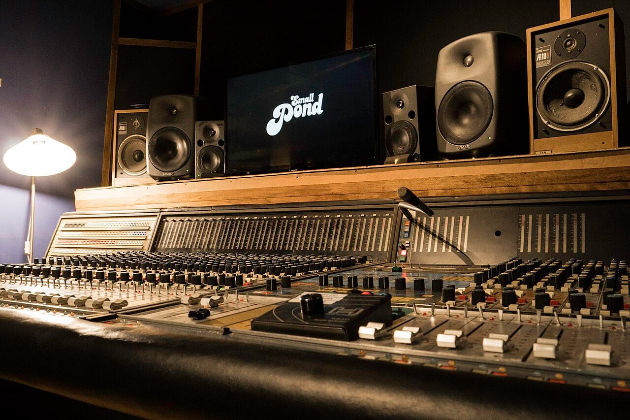 A mixing console splits a recording into separate instrument and vocal tracks, the job AI stem-separation tools now do in minutes