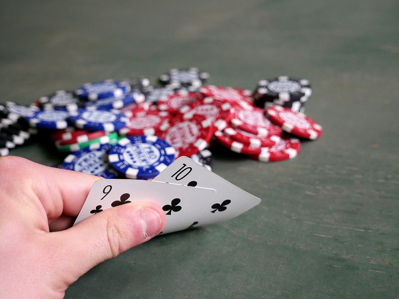 Two playing cards next to a stack of poker chips