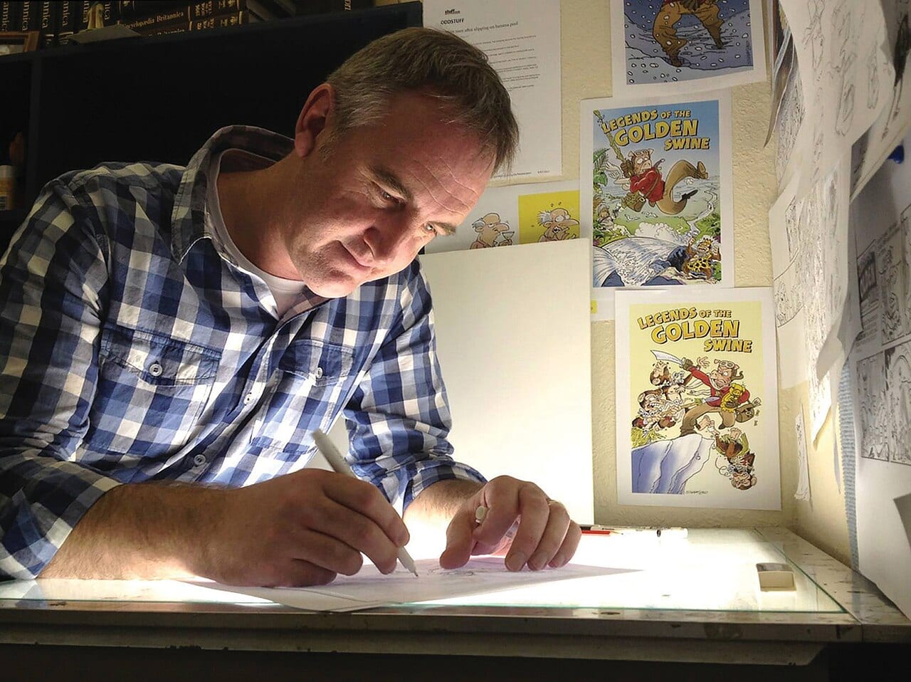Cartoonist Shaun Yeo draws at his desk at The Southland Times in 2015