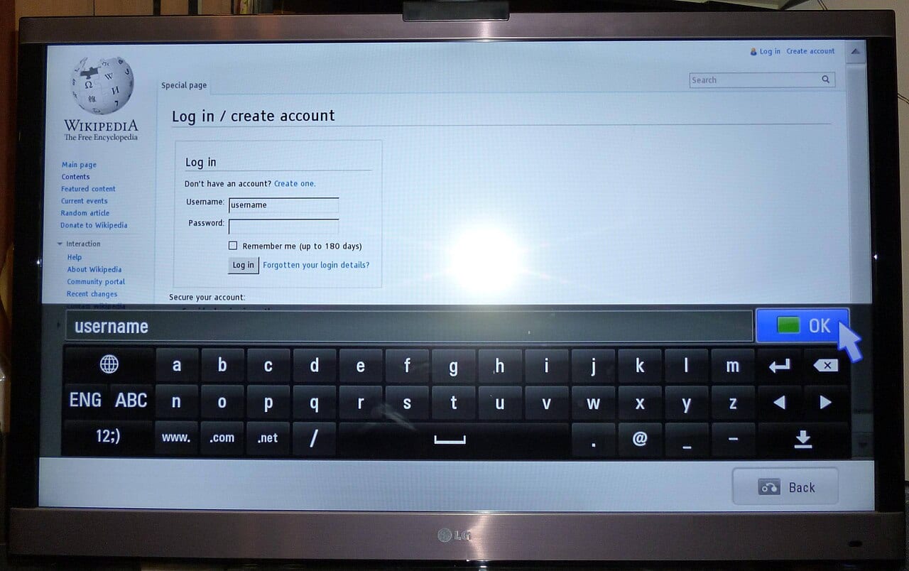 An LG Smart TV screen shows a web browser with an on-screen keyboard