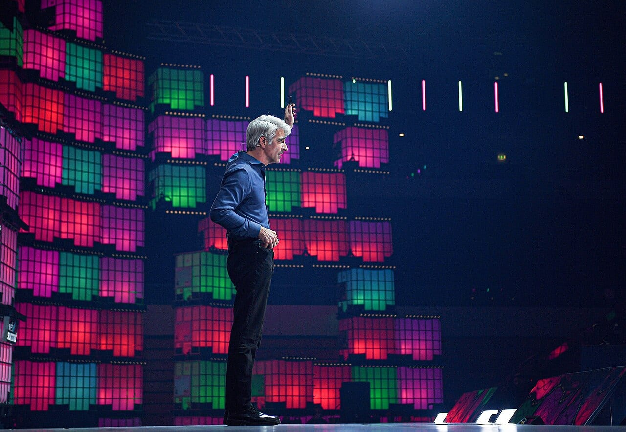 Craig Federighi speaks on stage at a technology conference