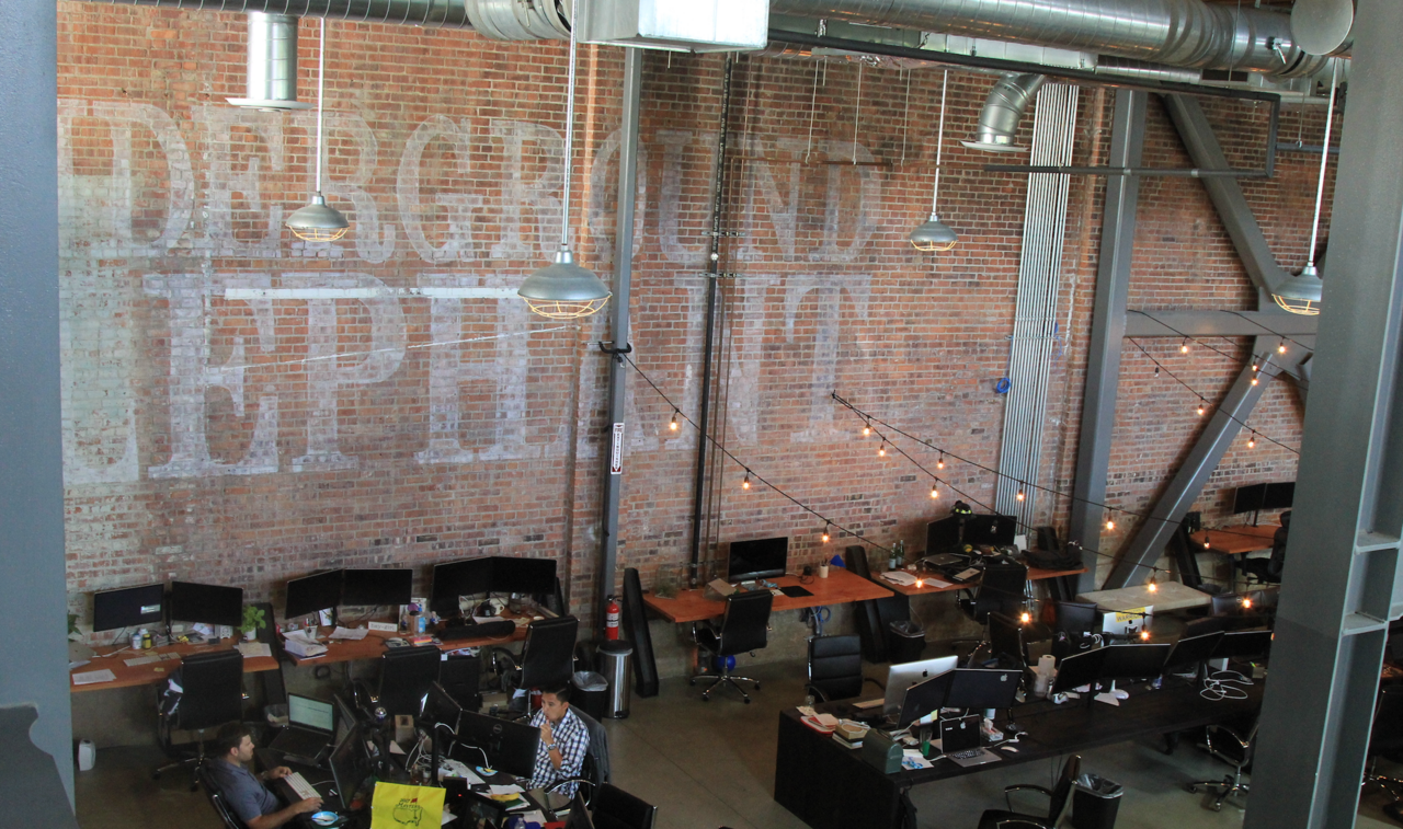 Employees work at desks in an open office instead of cubicles