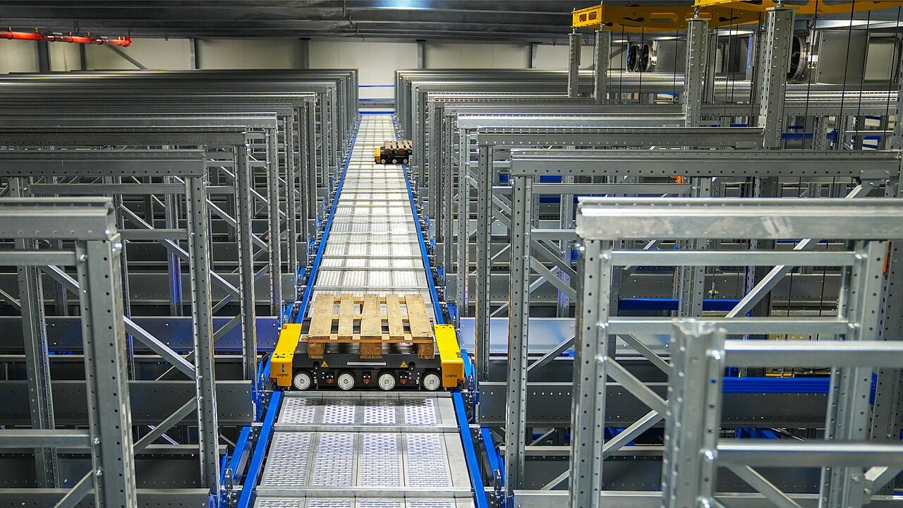 Robots move pallets through an automated warehouse, its aisles clear of human workers