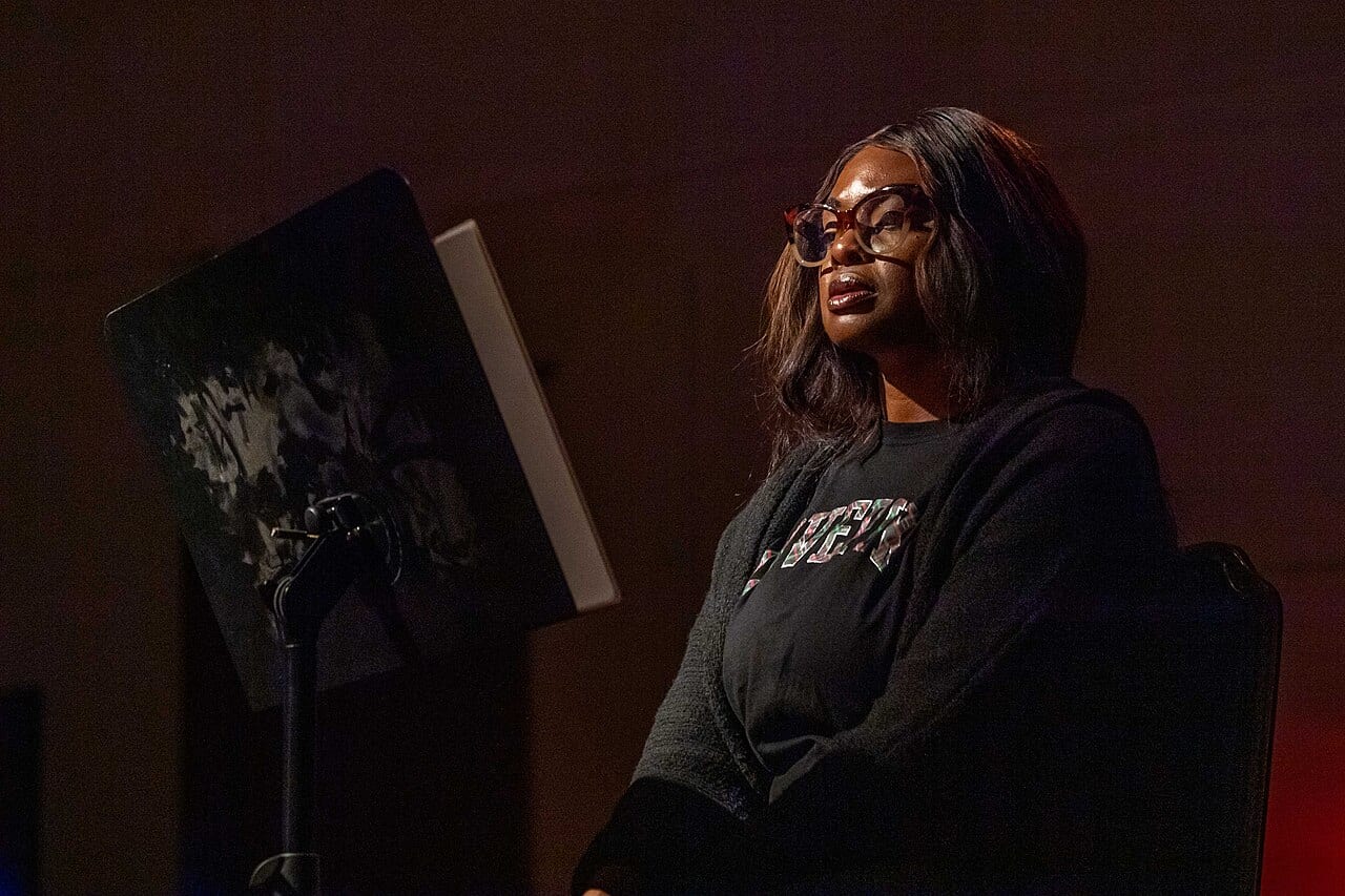 A sailor reads from a script during a staged reading rehearsal