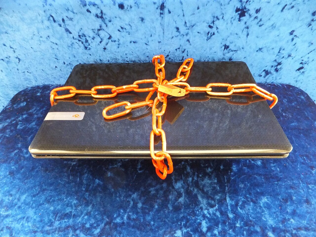 A padlock and chain secure a laptop