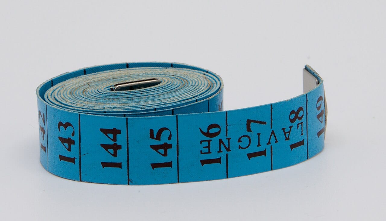A blue tape measure extended and marked in centimeters