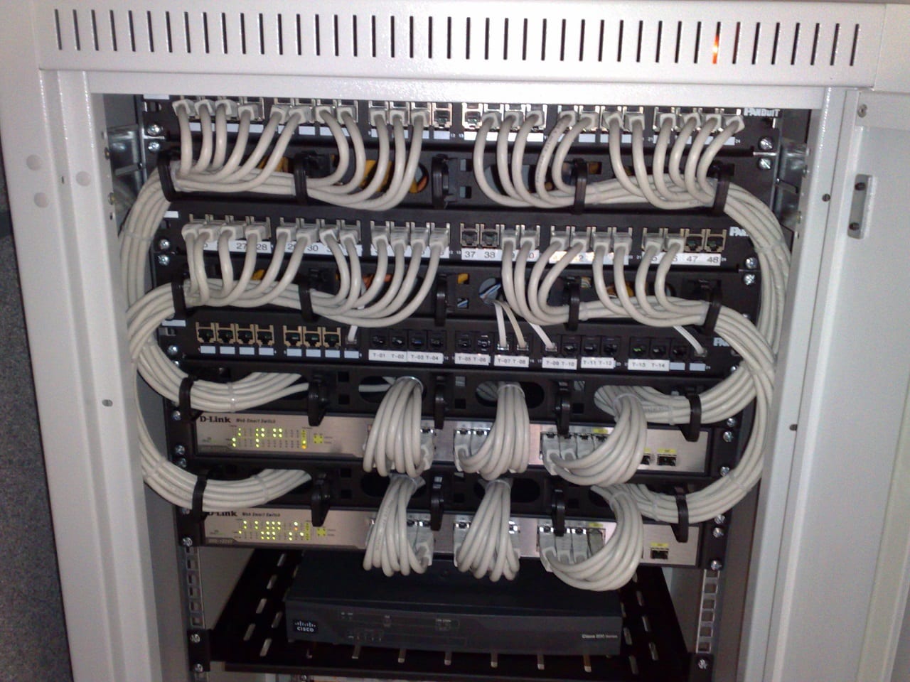 Rackmounted Ethernet switches and patch panels routing traffic in and out of a server rack