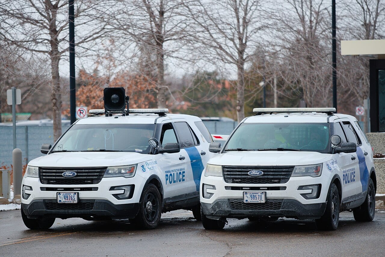 Protesters face Homeland Security Federal Protective Service officers outside the Whipple Building in Minneapolis in January 2026