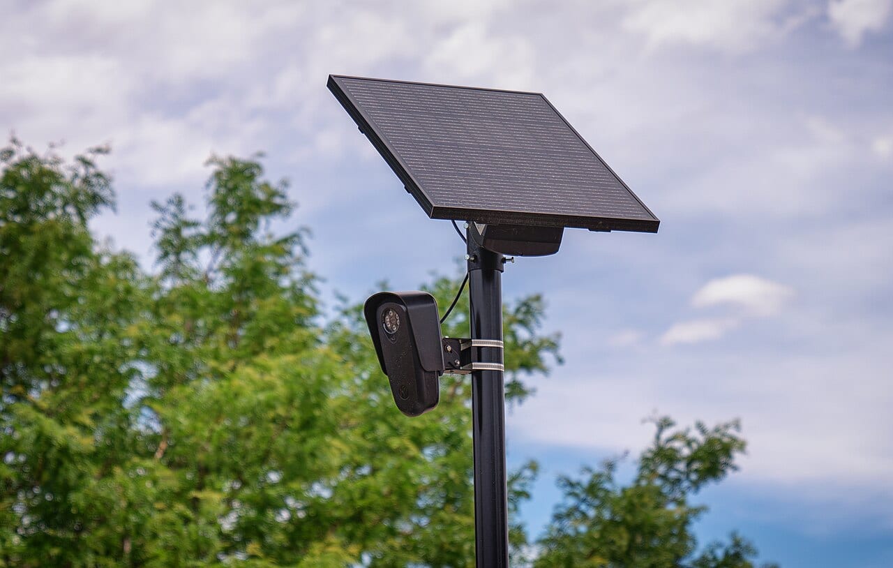 A Flock Safety license plate reader camera mounted on a pole outside a retail store