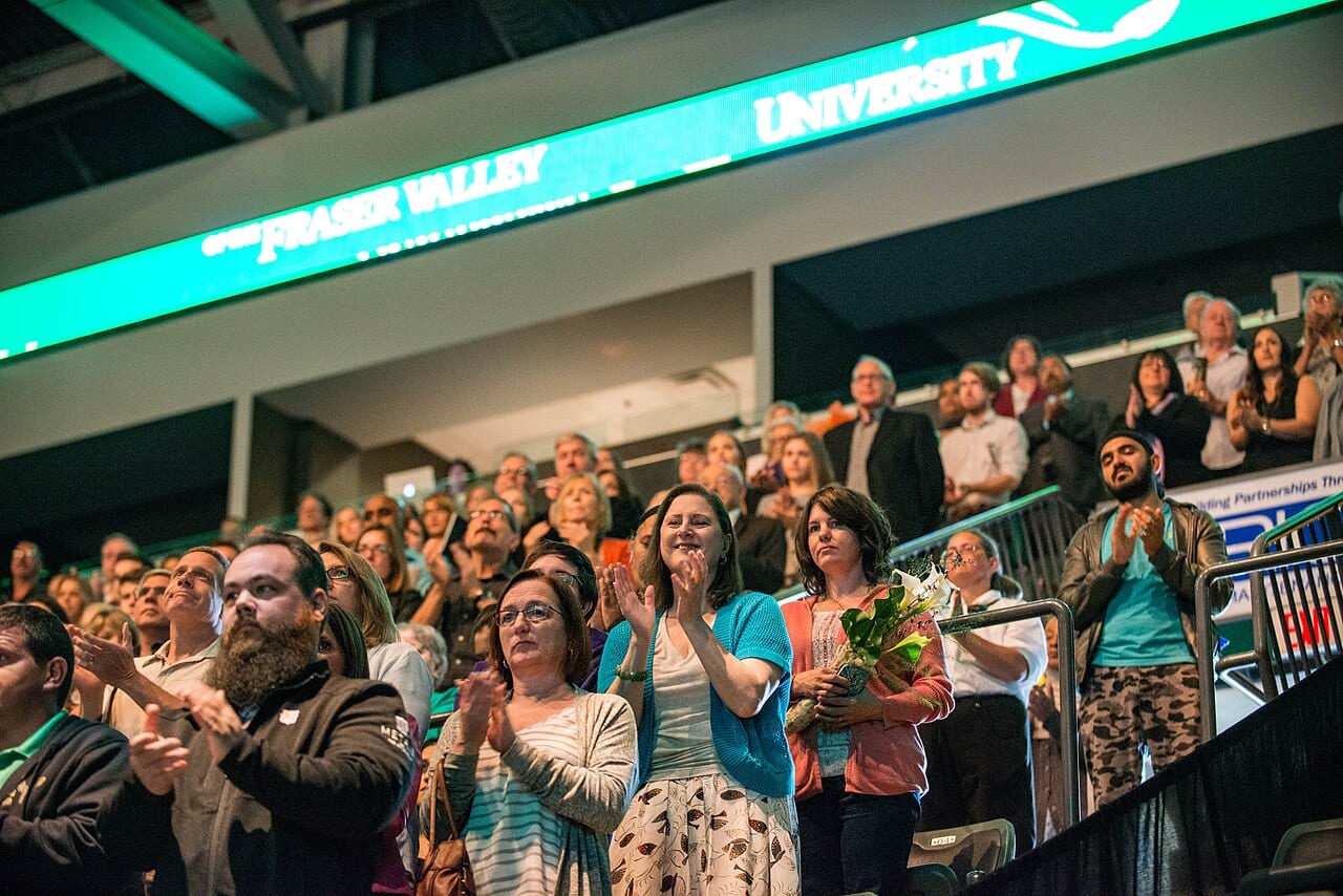 Graduates sit in a crowd at a university convocation ceremony