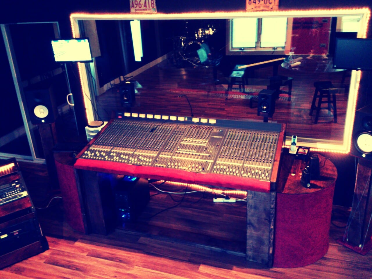 A recording studio control room with a mixing console