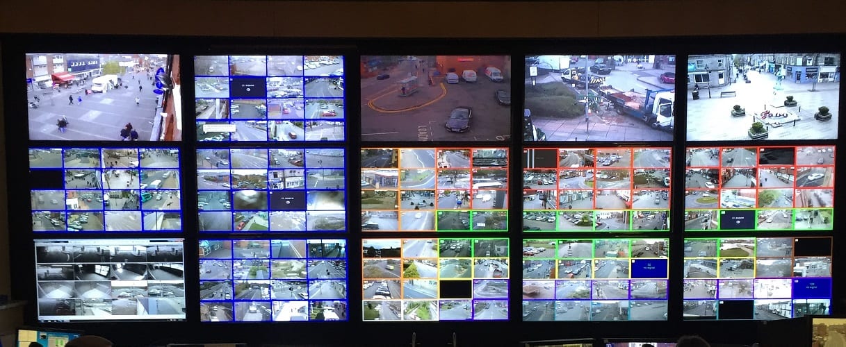 A wall of monitors inside a control room, each screen under constant watch