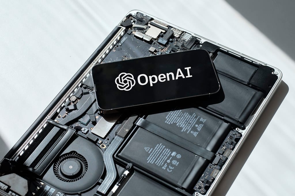 A phone screen displays the OpenAI name and logo
