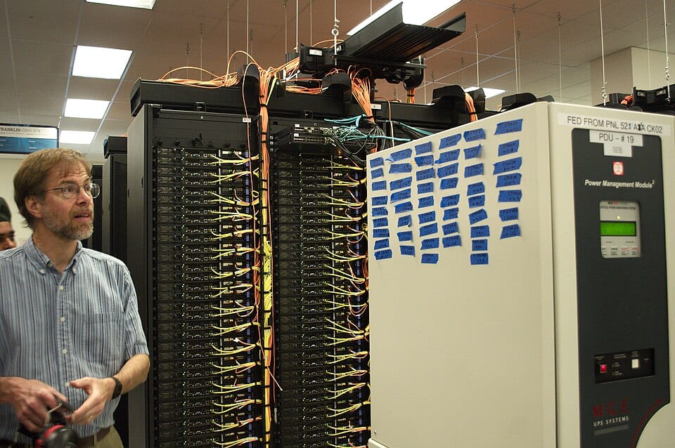 Networking cables run along research computing racks in a data center aisle