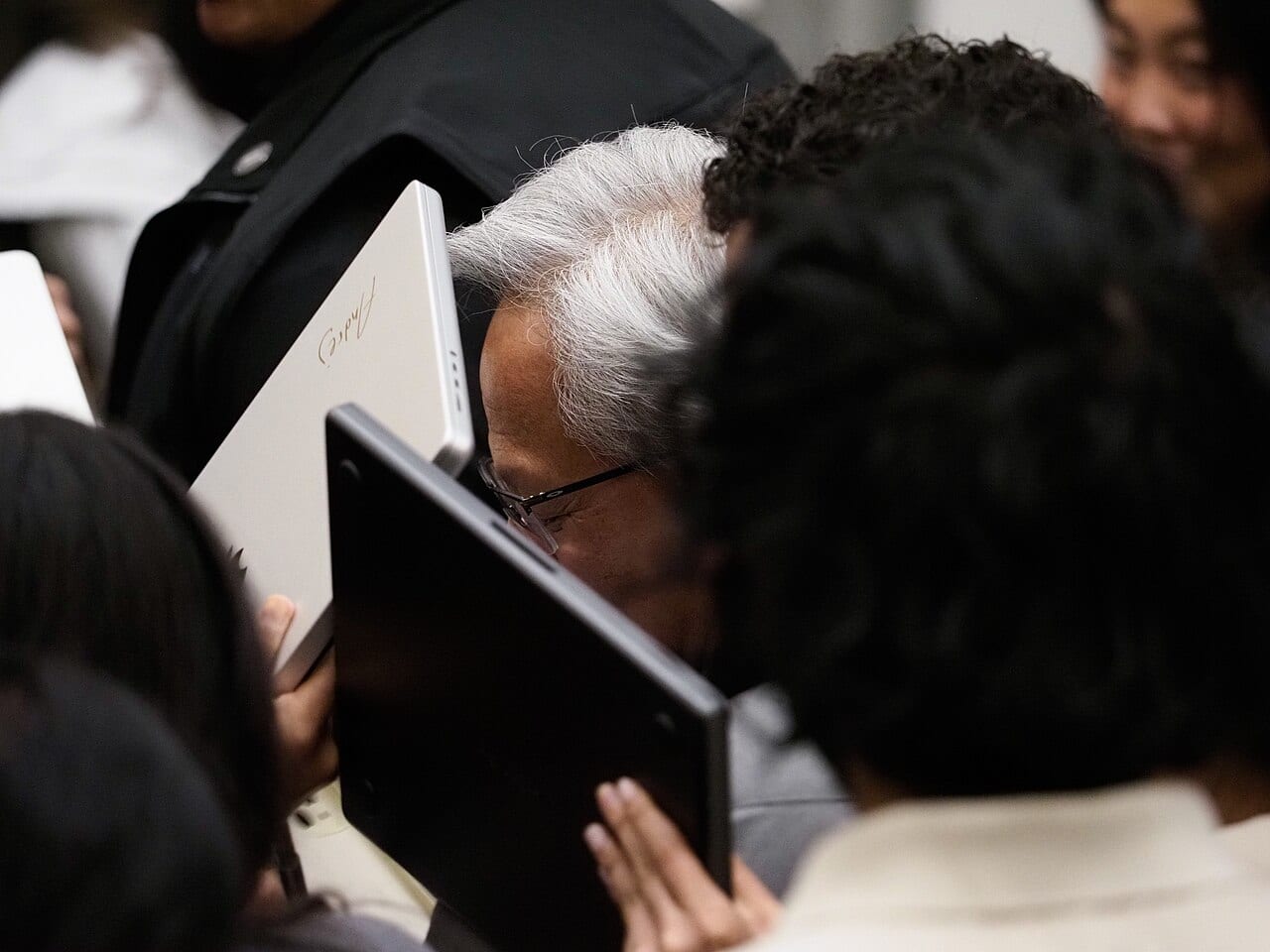 Jensen Huang, Nvidia's chief executive, signs a laptop after a talk at Stanford University