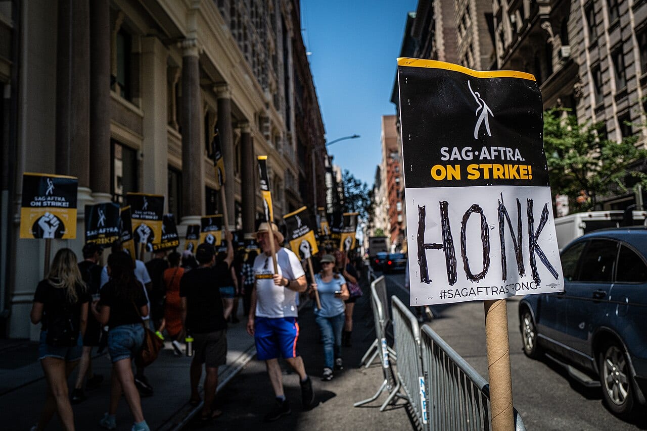 SAG-AFTRA members picket outside Warner Bros. offices, signs raised