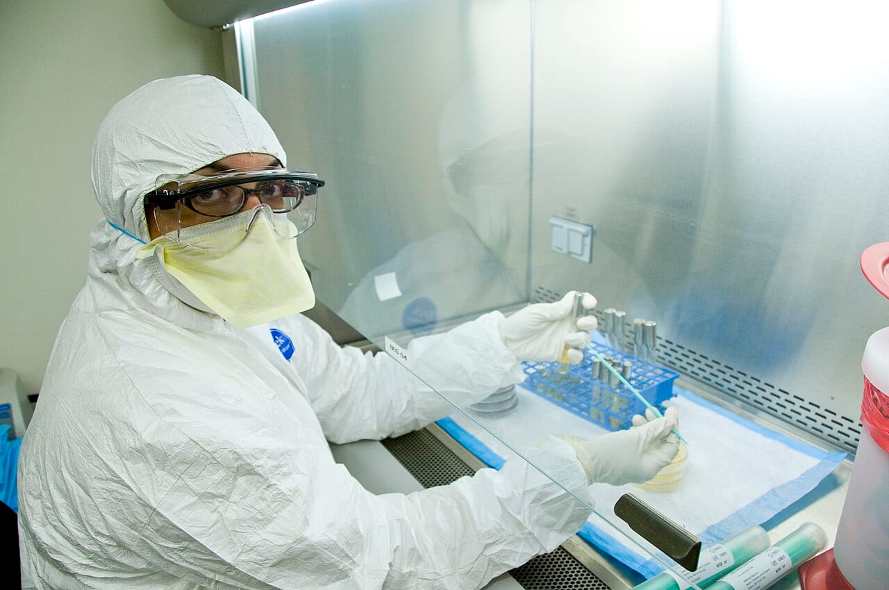 A microbiologist tests a sample for high-risk pathogens inside a biosafety laboratory