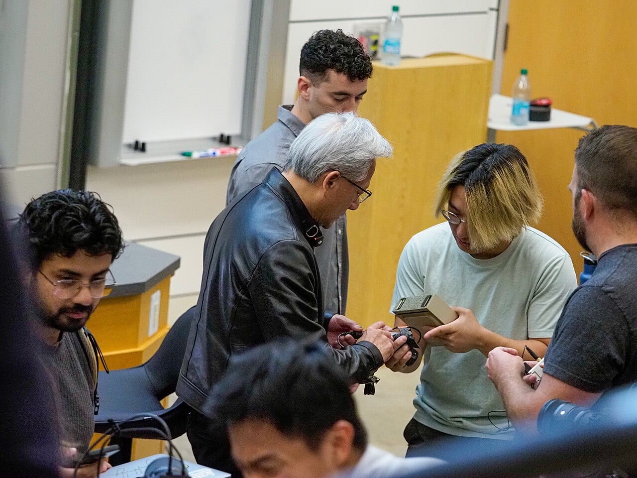 Jensen Huang signs a computer chip for a student after a Stanford talk