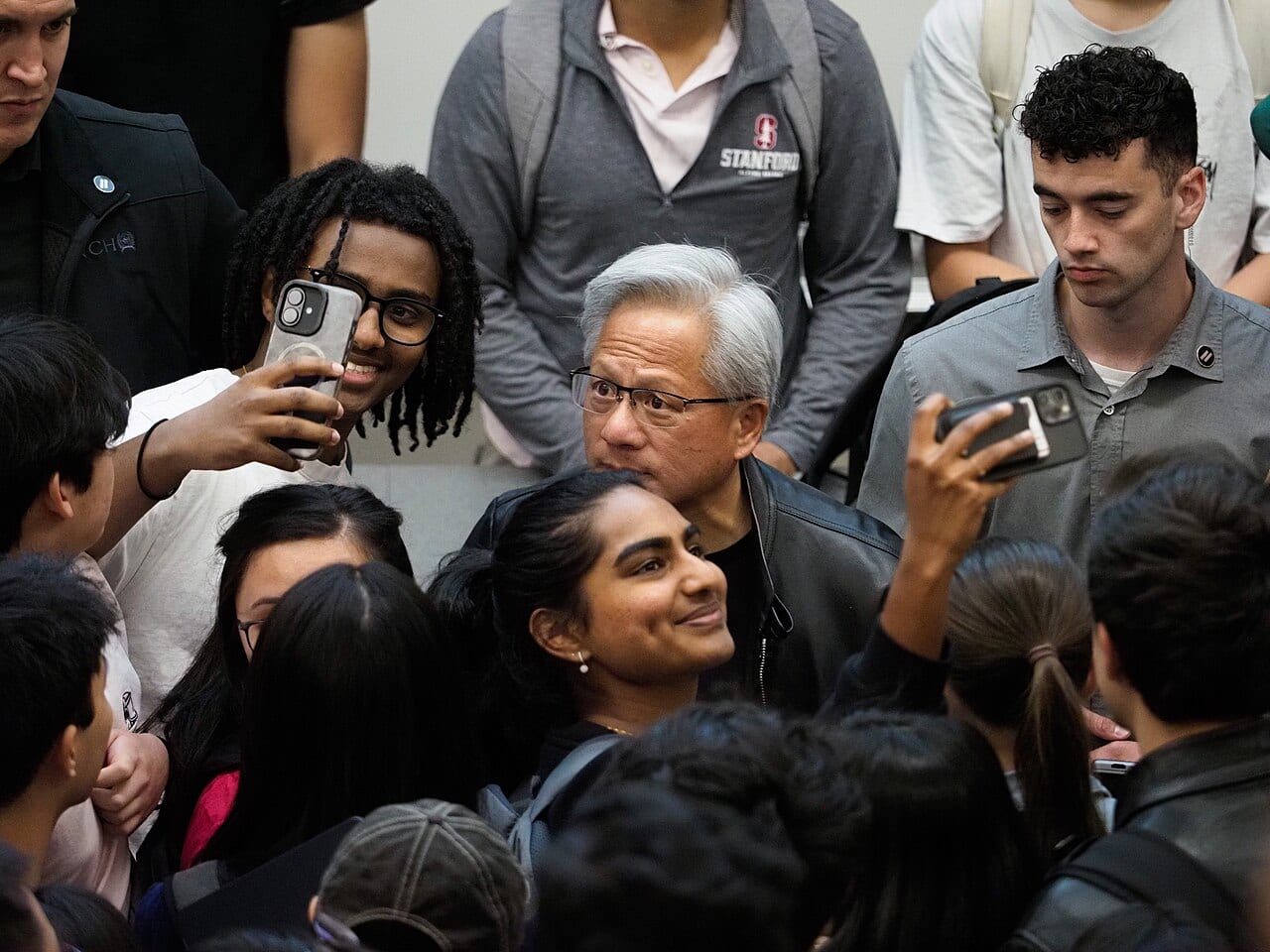 Jensen Huang, Nvidia's chief executive, poses for photos with students after a talk at Stanford University in April 2026